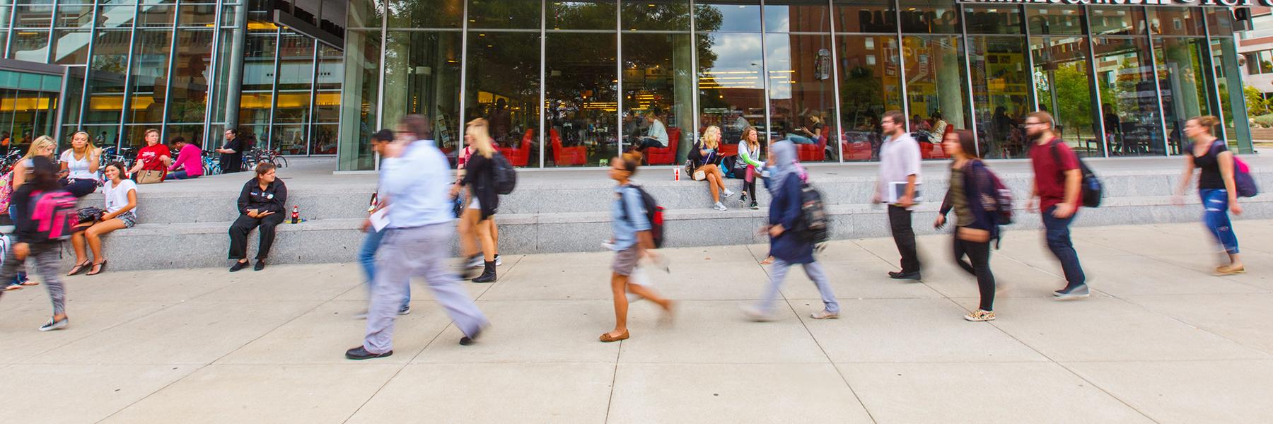 Various people walking by the campus center